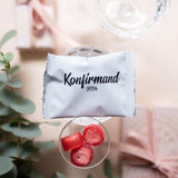 Weiße Konfirmationstüten mit schwarzem Aufdruck, gefüllt mit handgemachten Süßigkeiten
